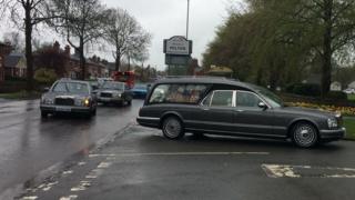 The funeral procession arrives at the crematorium