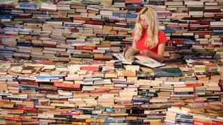 Joven frente a una pila de libros