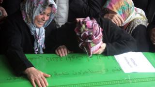 Family members mourn over a victim"s coffin as they attend funeral prayers for dormitory fire victims in Adana, Turkey on 1 December