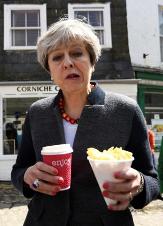Prime Minister Theresa May enjoys some chips during a campaign stop in Mevagissey, Cornwall, 2 May 2017.