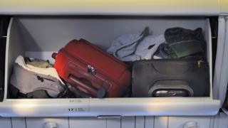 bags in overhead locker