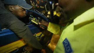 A Kenyan police-officer tests the alcohol-intake of a driver in this 23, December 2005 photo in Nairobi