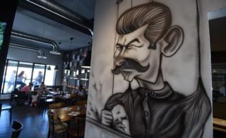 Cartoons adorn the walls of restaurant "The Dictator" on July 5, 2017 in the upmarket Cite Ennasr suburb of Tunis. A steak named "Grilled Freedom" is just one of many dishes that stand out on the menu of the Tunisian capital"s "Le Dictateur" restaurant, not a favourite venue for the authorities. Six years after the country's revolution that sparked the Arab Spring, "Le Dictateur" vies for business.