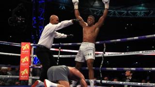 Joshua, Klitschko yerde yatarken yumruklarını havaya kaldırıyor.