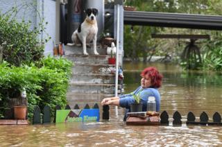 A woman attempts to access her home as her dog looks on in central Lismore, New South Wales, Australia, 31 March 2017.