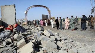 Afghan security forces and civilians walk at the site of a suicide attack in Lashkar Gah, capital of Helmand province, Afghanistan - 4 June 2015
