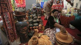 A woman makes clay pots during the opening ceremony of a tourism fair in Ivory Coast's main city of Abidjan on 27 April 2018