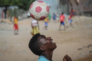 A Somali child plays football on the Lido beach in Mogadishu, on January 12, 2018.