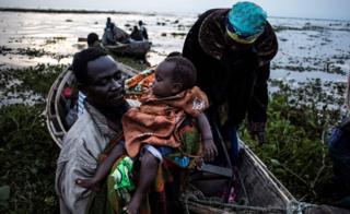 Internally displaced Congolese return to the shore line of lake Albert after spending the night out in the lake for safety on March 05, 2018 in Tchomia. Displaced Congolese, fleeing inter-communal violence in the Ituri region of the Democratic Republic of the Congo, make their way to the Tchomia on the DRC side of Lake Albert in search of safety and boats to make the crossing to the safety of the refugee camps in Uganda