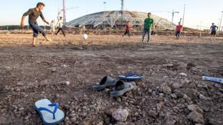 Operários jogam bola perto do estádio em Samara