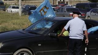 полицейский и машина с флагом крымских татар