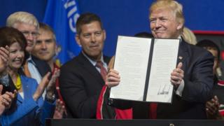 Donald Trump mostrando la orden ejecutiva.