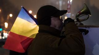 People protest in front of the government headquarters in Victory Square in central Bucharest on 7 February