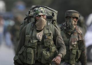 Indian soldiers leave the site of a gun battle in Pampore, on the outskirts of Srinagar, Indian-controlled Kashmir, 12 October