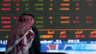 A Kuwaiti trader follows the stock market activity at the Kuwait Stock Exchange (KSE) on 31 December 2015 in Kuwait City