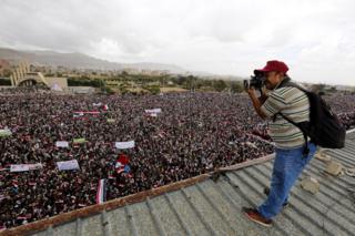 Sawir qaade reer Yemen ah oo sawiraya dad isugu soo baxay magaalada Sanca