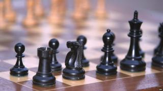 Chess pieces on board. Black pieces, rook, knight, bishop, king and pawns.