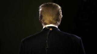 Trump dons an earpiece ahead of a primary debate hosted by Fox Business