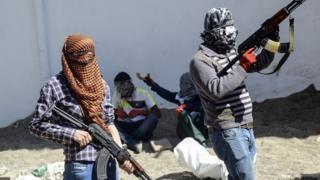 Kurdish militants stand behind a barricade during fighting with Turkish forces