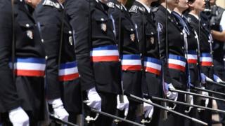 Newly promoted police officers stand guard during a ceremony of the 20th promotion of the police officers at the Saint-Cyr national school of police on June 24, 2016 in the Saint-Cyr-au-Mont-d"Or near Lyon