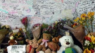 Messages of condolence are written on a wall outside Latymer Community Church