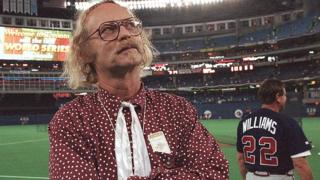 WP Kinsella stands on a baseball field in 1992