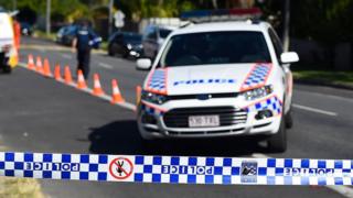A Queensland Police car outside a crime scene