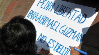 Persona escribiendo en un cartel "Pedir libertad para Abimael Guzmán no es delito".