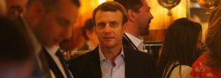 Emmanuel Macron (hagati) niwe yikekwa gutsinda amatora yo ku munsi wa Mungu ku bice 60%