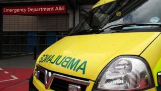 an ambulance outside an entrance to a hospital Accident and Emergency department