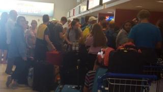 Passengers queue for information at Belfast International Airport