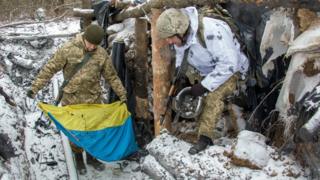 Ukrainian servicemen take Ukrainian National flag from a shelter damaged after shelling, in a front line near Novognatovka, Donetsk area, Ukraine, 07 February 2017.