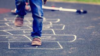 Plentyn yn chwarae hopscotch