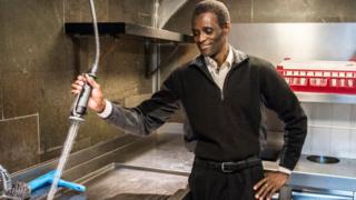 Employee Ali Sonko poses in the kitchen of Noma restaurant in Copenhagen