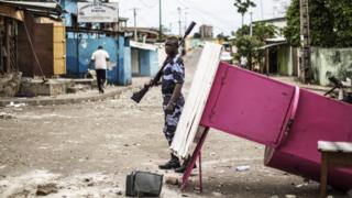 A police officer patrols near a barricade in Libreville in an attempt to secure neighbourhoods from looters, 2 September 2016