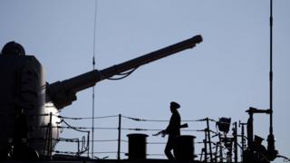 A Russian Navy member stands guard on the deck of the Pyotr Velikiy (Peter the Great) Russian nuclear-powered missile cruiser docked in the Cypriot port of Limassol, on 12 February 2014