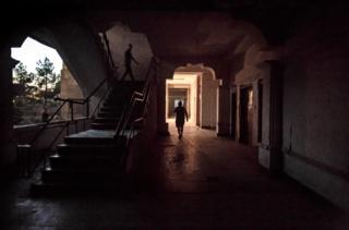 Residents walk through the first floor hallway at dusk
