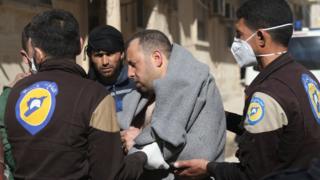 A man is helped by rescue workers following a suspected chemical attack in Khan Sheikhoun, Idlib province, Syria (4 April 2017)