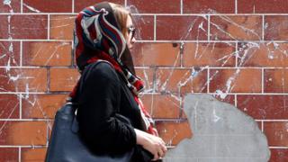 A woman walks down a street in Tehran, Iran (28 April 2016)