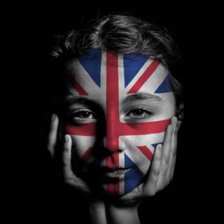Joven con cara pintada con la bandera británica