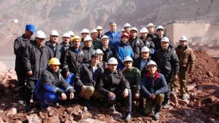 Workers pose in a group photo with the President