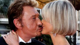 Cast member Johnny Hallyday and his wife Laeticia kiss during red carpet arrivals for the screening of the film "Vengeance"
