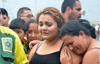Relatives wanting information about their loved ones gather outside a beer distribution centre after it was attacked in the town of Garcia, on the outskirts of the northern city of Monterrey, Mexico, Friday, June 19, 2015