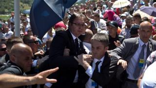 Serbian PM Aleksandar Vucic, centre, is seen during a scuffle at the Potocari memorial complex near Srebrenica