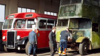 A 1933 AEC Regent with a 1947 body being pushed by group members beside a 1950 Leyland Tiger