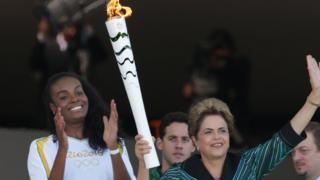 President Dilma Rousseff holds the Olympic torch it was ignited at the presidential palace in Brasilia, Brazil, Tuesday, May 3, 2016.