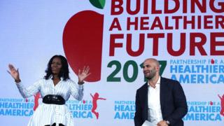 Michelle Obama addresses a Healthier America Summit with former White House cook and Senior Policy Advisor for Nutrition Policy Sam Kass. 12 May 2017