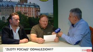Andreas Richter, left, and Piotr Koper, centre, speak on Polish television