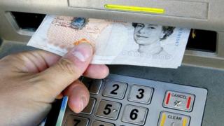 Person taking money out of a cashpoint