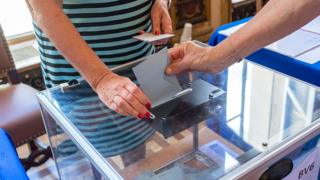 Un français accomplit son devoir citoyen dans un bureau de vote à Paris